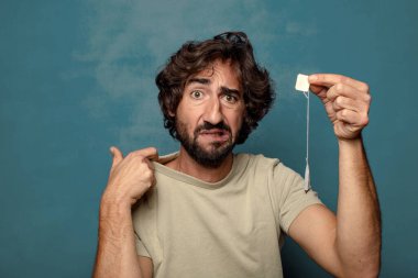 Genç, sakallı, çay içen bir adam.