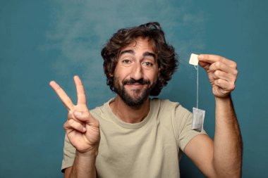 Genç, sakallı, çay içen bir adam.