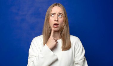 Şaşırmış, gergin, endişeli ya da korkmuş bir bakışla, kopya boşluğuna doğru bakıyor.