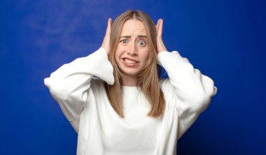 Stresli, endişeli, endişeli ya da korkmuş hissediyorum, ellerim başımda, yanlışlıkla panikliyorum.