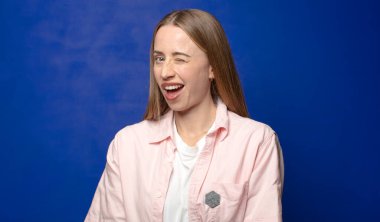 Mutlu ve arkadaş canlısı görünüyor, gülümsüyor ve sana olumlu bir tavırla göz kırpıyor.