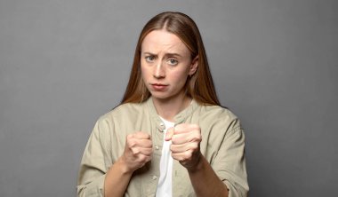 Kendinden emin, sinirli, güçlü ve agresif görünüyor. Yumrukları boks pozisyonunda dövüşmeye hazır.