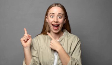 Neşeli ve şaşırmış hissediyorum, şok olmuş bir ifadeyle gülümsüyorum ve bir tarafı işaret ediyorum.