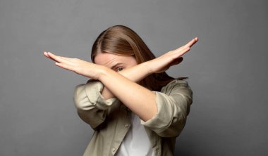 Yüzünü eliyle kapatıyor ve kamerayı durdurmak için diğer elini öne koyuyor, fotoğraf ya da resimleri reddediyor.