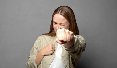 Kendinden emin, sinirli, güçlü ve agresif görünüyor. Yumrukları boks pozisyonunda dövüşmeye hazır.