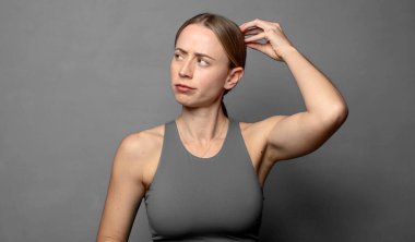 Şaşırmış ve kafası karışmış hissediyorum, başımı kaşıyorum ve yan tarafa bakıyorum. fitness konsepti