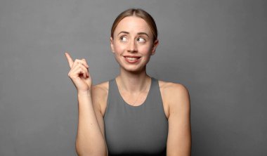 Mutlu bir şekilde gülümsüyor ve yan bakıyor, merak ediyor, düşünüyor ya da bir fikir üretiyor. fitness konsepti