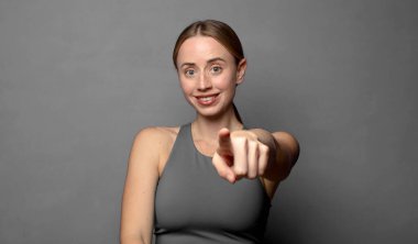 Tatmin olmuş, kendine güvenen, dostça gülümseyen ve seni seçen bir kameraya. fitness konsepti