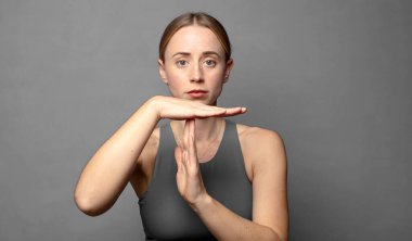 Ciddi görünüyor, sert, kızgın ve hoşnutsuz, mola işareti yapıyor. fitness konsepti