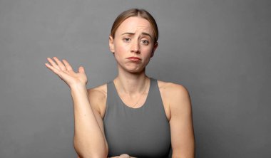 Gururla ve özgüvenle gülümsüyor, mutlu ve tatmin olmuş hissediyor ve fotokopi alanında bir konsept gösteriyor. fitness konsepti