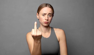 Öfkeli, sinirli, asi ve agresif hissederek, orta parmağını sallayarak, karşılık vererek. fitness konsepti