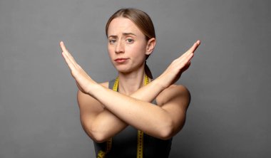 Bu tavrından rahatsız ve bıkkın görünüyorsun, yeter artık! Eller önde çapraz, sana durmanı söylüyor. fitness konsepti