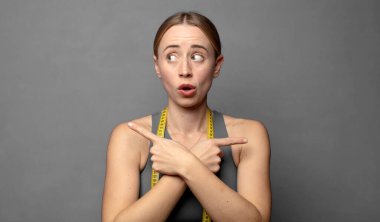 Şaşırmış ve kafası karışmış görünüyor, güvensiz ve zıt yönlere şüpheyle bakıyor. fitness konsepti