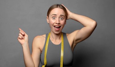 Gülen, mutlu görünen, pozitif ve şaşırmış görünen, yanal fotokopi alanını işaret eden harika bir fikrin farkına varan. fitness konsepti