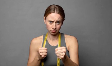 Kendinden emin, sinirli, güçlü ve agresif görünüyor. Yumrukları boks pozisyonunda dövüşmeye hazır. fitness konsepti