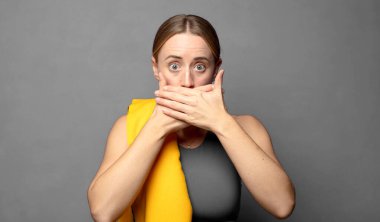 Şok olmuş, şaşırmış bir ifadeyle ağzı kapalı, sır saklayan ya da 