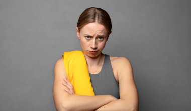 Hoşnutsuz ve hayal kırıklığına uğramış hissediyorum, ciddi görünüyor, kızgın ve çapraz kollara kızgın. fitness konsepti