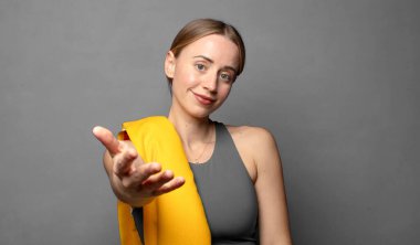 Gülümsüyor, mutlu görünüyor, kendine güvenen ve arkadaş canlısı, bir anlaşmaya varmak için el sıkışmayı teklif ediyor, işbirliği yapıyor. fitness konsepti