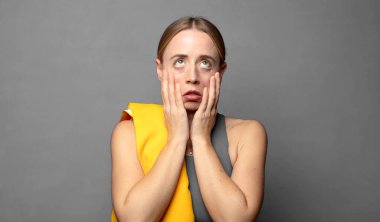 Şok olmuş ve korkmuş hissediyorum, yanaklarındaki ellerden sıkılmış gibiyim. fitness konsepti