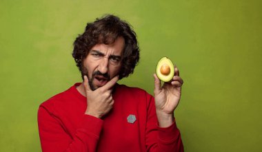 Avokadosu olan sakallı genç bir adam.