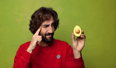 Avokadosu olan sakallı genç bir adam.