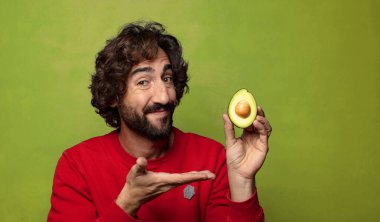 Avokadosu olan sakallı genç bir adam.