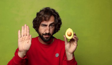 Avokadosu olan sakallı genç bir adam.