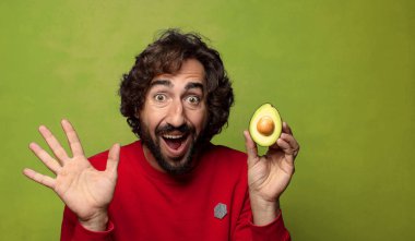 Avokadosu olan sakallı genç bir adam.
