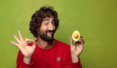 Avokadosu olan sakallı genç bir adam.