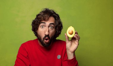 Avokadosu olan sakallı genç bir adam.