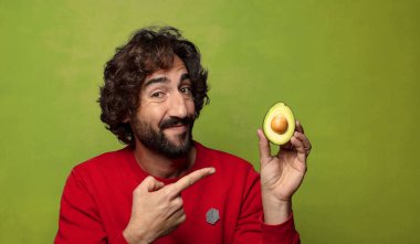 Avokadosu olan sakallı genç bir adam.