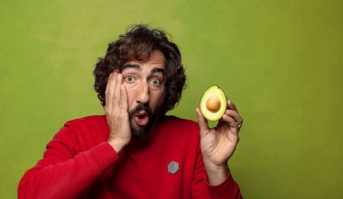Avokadosu olan sakallı genç bir adam.