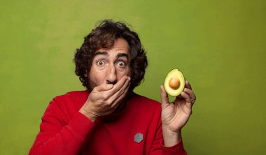 Avokadosu olan sakallı genç bir adam.