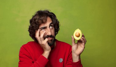 Avokadosu olan sakallı genç bir adam.
