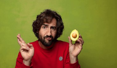 Avokadosu olan sakallı genç bir adam.