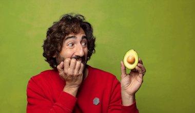 Avokadosu olan sakallı genç bir adam.