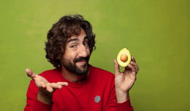 Avokadosu olan sakallı genç bir adam.