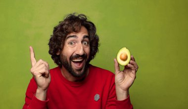 Avokadosu olan sakallı genç bir adam.