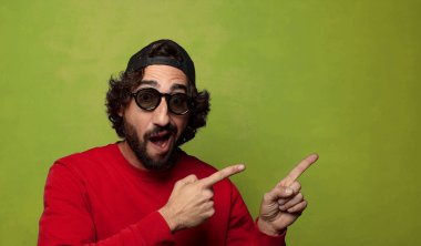 Şapkalı ve güneş gözlüklü genç, sakallı adam.