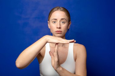 Sarışın kadın ciddi, sert, kızgın ve hoşnutsuz görünüyor.