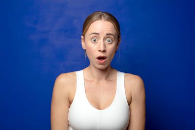 Sarışın kadın çok şaşırmış ya da şaşkın bakıyor, ağzı açık bir şekilde 