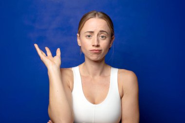 Sarışın kadın gururla ve gururla gülümsüyor, mutlu ve tatmin olmuş hissediyor ve fotokopi alanında bir konsept gösteriyor.