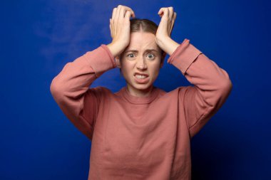 Sarışın bir kadın unutulmuş bir teslim tarihi yüzünden panikliyor, stresli hissediyor, bir pisliği veya hatayı örtbas etmek zorunda kalıyor.