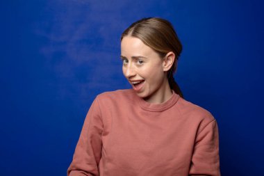 Büyük, dostane, kaygısız gülüşü olan, pozitif, rahat ve mutlu, ürpertici görünen sarışın kadın.