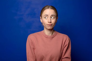 Sarışın kadın merak ediyor, mutlu düşünceler ve fikirler düşünüyor, hayal kuruyor, kenarda yer arıyor.