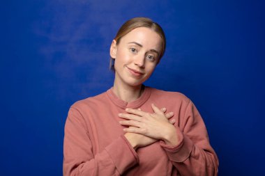 Sarışın kadın romantik, mutlu ve aşık, neşeyle gülümseyen ve kalbe yakın el ele tutuşan