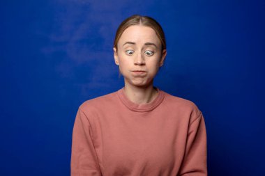 Sarışın kadın stresli, mutsuz ve hayal kırıklığına uğramış, alnına dokunuyor ve şiddetli baş ağrısı çekiyor.