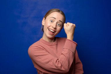 Sarışın kadın mutlu, pozitif ve başarılı hissediyor, meydan okumayla karşılaştığında motive oluyor ya da iyi sonuçları kutluyor.