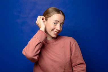 Sarışın kadın neşeli ve tesadüfen gülümsüyor, olumlu, mutlu ve kendinden emin bir bakışla kafa kafaya tutuşuyor.