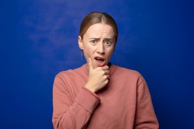 Sarışın, ağzı ve gözleri açık ve eli çenesinde olan bir kadın. Hoş olmayan bir şok geçiriyor. Ne diyor?